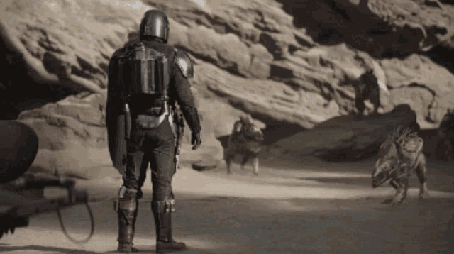 a man in a helmet stands in a desert holding a shield
