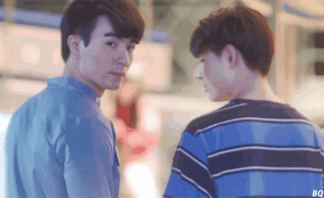 two young men are looking at each other with the letters bq on the bottom right