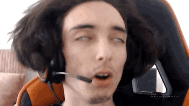a man wearing headphones and a microphone making a funny face
