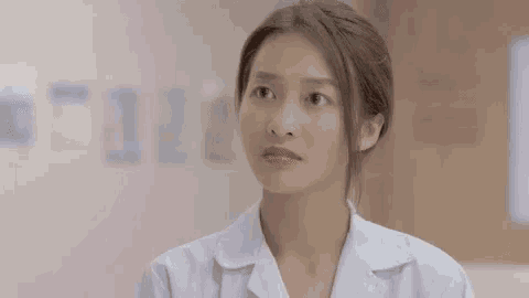 a woman in a white coat is making a funny face in front of a sign that says thiet va