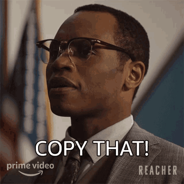 a man wearing glasses and a suit says copy that in a prime video ad