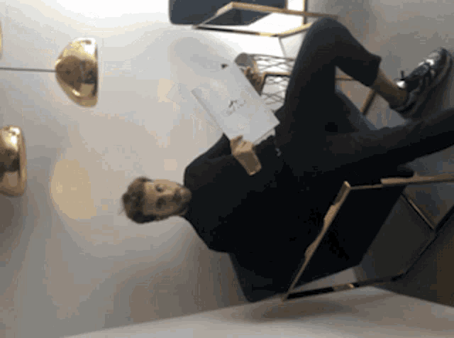 a man sitting in a chair holding a book that says ' i love you '