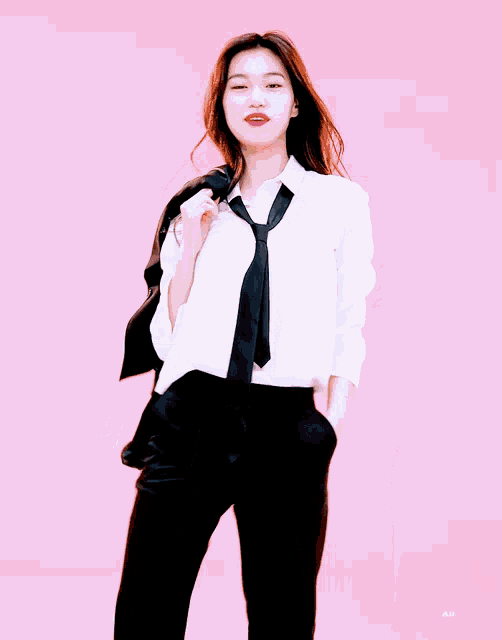 a girl wearing a white shirt and black tie is holding a black jacket