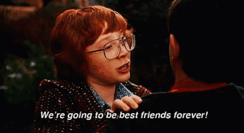 a red haired boy wearing glasses is talking to another boy .
