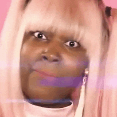 a close up of a woman wearing a pink wig and earrings .