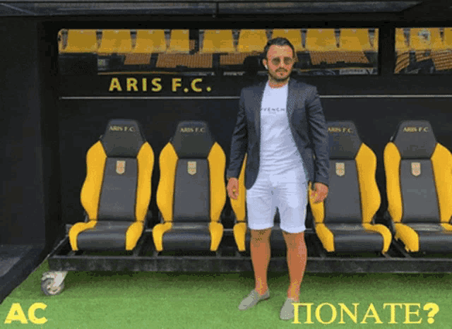 a man in a suit stands in front of a baris f.c. locker room