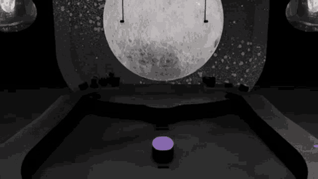 a stage with a large moon in the background and purple lights