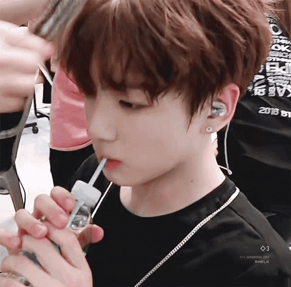 a young boy is drinking from a straw .