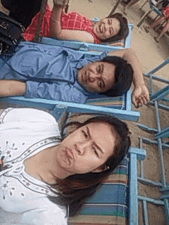 a man and two women laying in lawn chairs on a beach