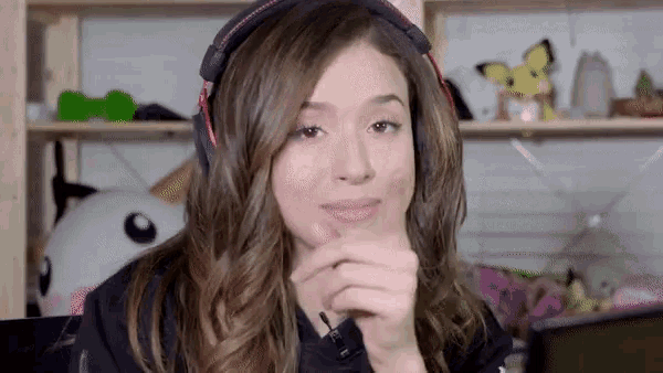 a woman wearing headphones and a black shirt looks at the camera