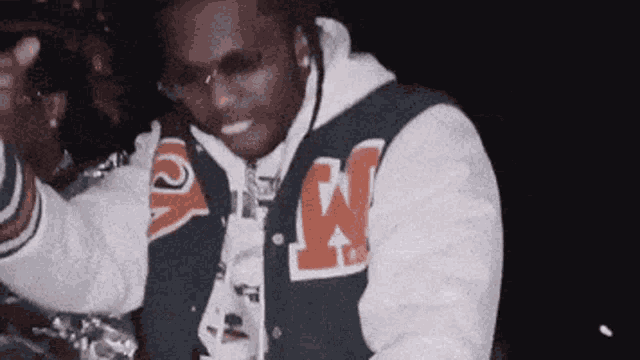 a man in a varsity jacket with the letter w on it