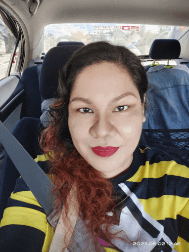 a woman in a striped shirt is taking a selfie in a car with a date stamp of 2021/05/02 12:46