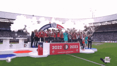 a group of people standing on a podium with the year 2022 and 2023 written on it