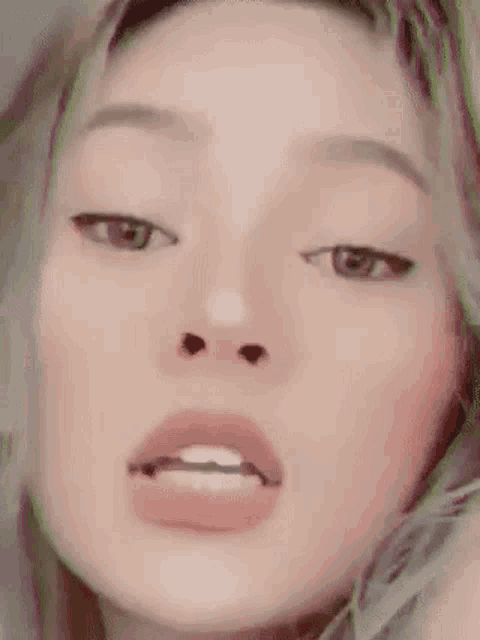 a close up of a woman 's face with her eyes closed and her mouth open .