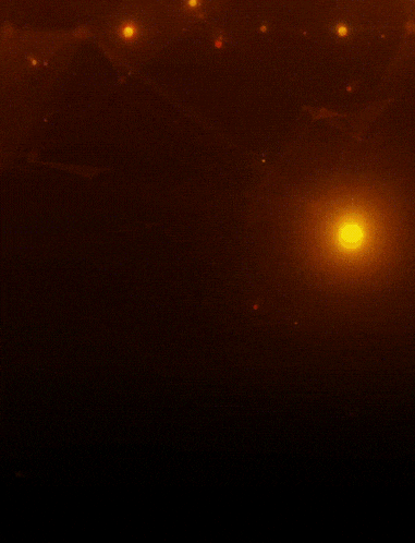 a dark background with a few lights on it