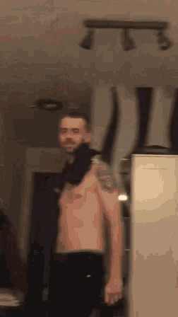 a shirtless man with a scarf around his neck is standing in front of a mirror .
