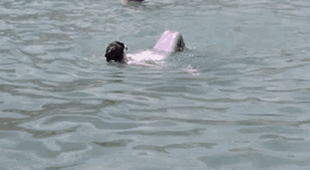 a man is swimming in the ocean with a mermaid tail .