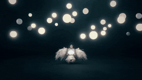 a woman with angel wings is holding a light in her hand