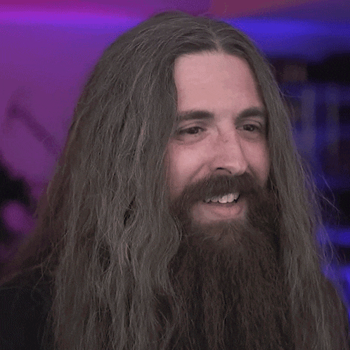 a man with long hair and a beard says he loves his shirt