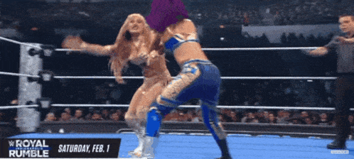two women wrestling in a ring with a sign that says saturday feb 1