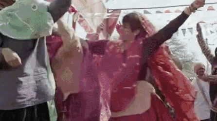a woman in a red dress is dancing in front of a crowd of people wearing masks .