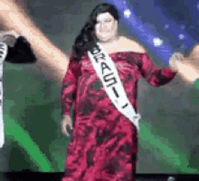 a woman in a red dress is wearing a sash that says brasil on it