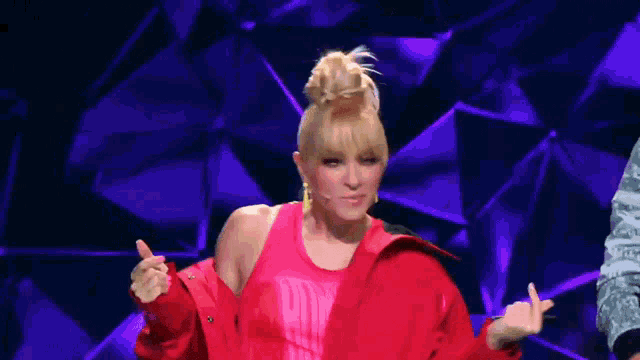a woman wearing a red jacket and a pink tank top