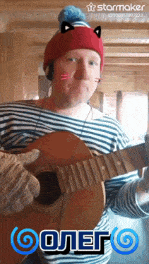 a man wearing a cat hat is playing a guitar with a starmaker logo in the background