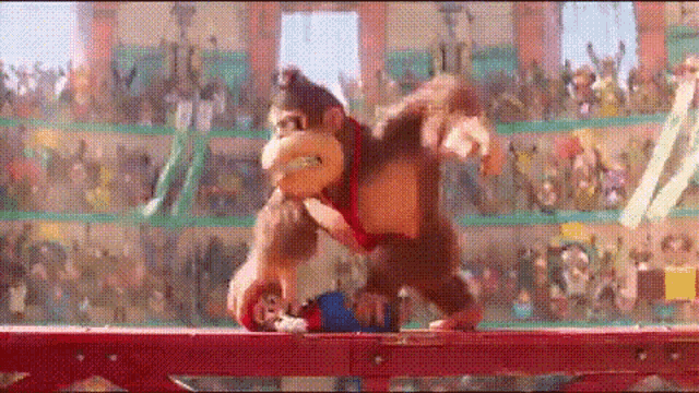 donkey kong is walking across a bridge in front of a crowd of people .