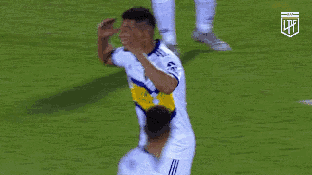 a soccer player with the number 1 on his jersey holds his hand to his head