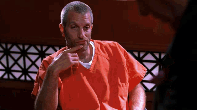 a man in an orange prison uniform has a white shirt on