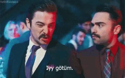 two men in suits and ties are standing next to each other and one of them is saying " ivy gotum "