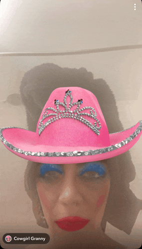 a woman wearing a pink cowboy hat with rhinestones on it