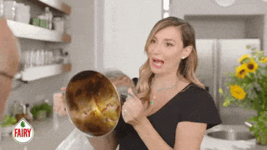 a woman is holding a dirty pot in a kitchen with a fairy logo in the background