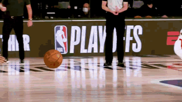 a basketball is on the floor in front of a nba sign