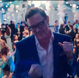 a man in a suit and glasses is dancing in a crowd