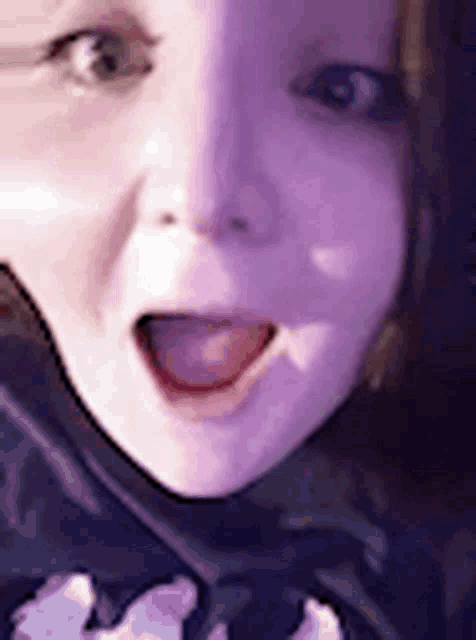a close up of a woman 's face with her tongue out and a surprised look on her face .