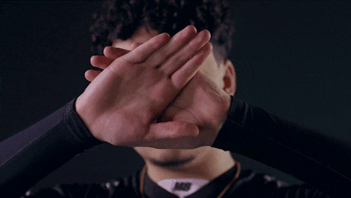 a man making a circle with his hands with the letter m on his shirt