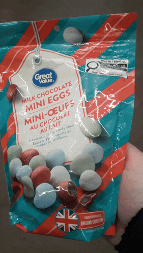 a bag of milk chocolate mini eggs is being held in someone 's hand
