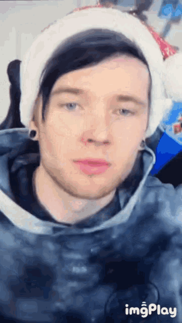 a young man wearing a santa hat and a tie dye sweatshirt