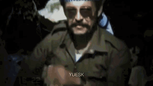a man wearing a head scarf and sunglasses says yuesk