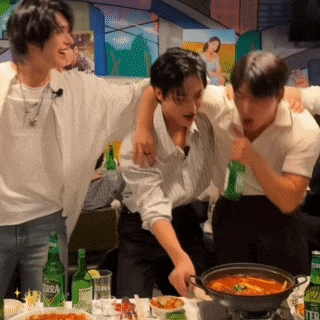 a group of men are standing around a table with bottles of terra beer