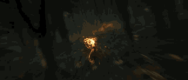 a pyramid is surrounded by flames and smoke in a dark room