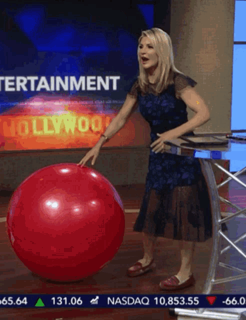 a woman stands in front of a screen that says " entertainment "