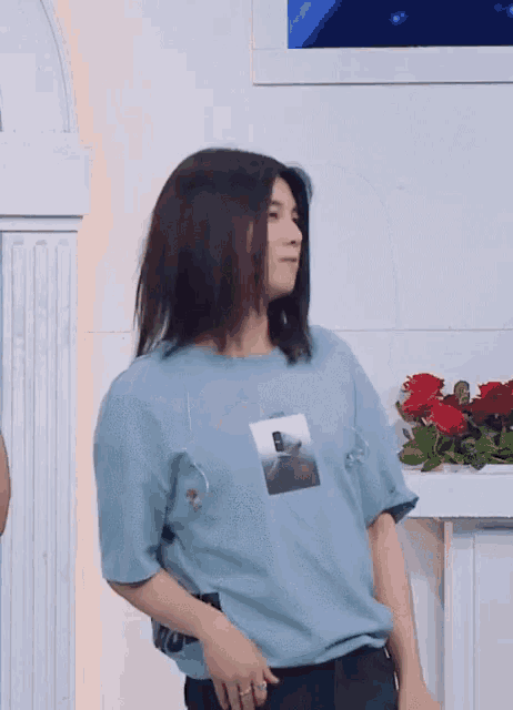 a man with long hair wearing a blue shirt with a picture of a man on it