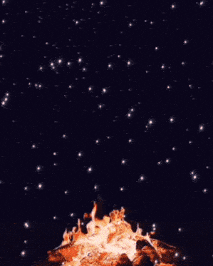 a fire is burning in the middle of a field at night