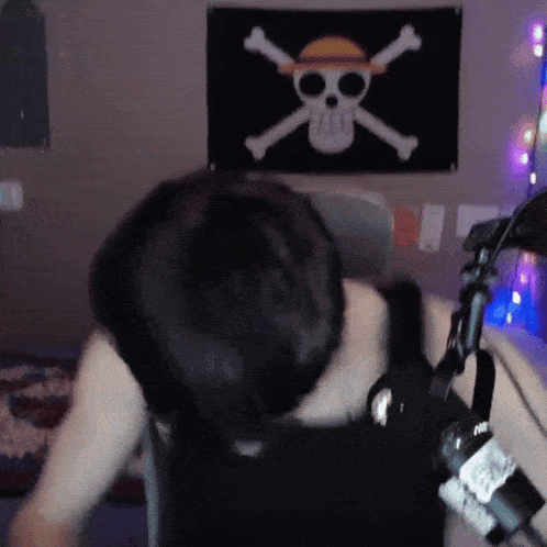 a person is sitting in front of a pirate flag