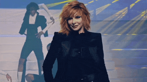 a woman with red hair is wearing a black jacket with the letter e on the front