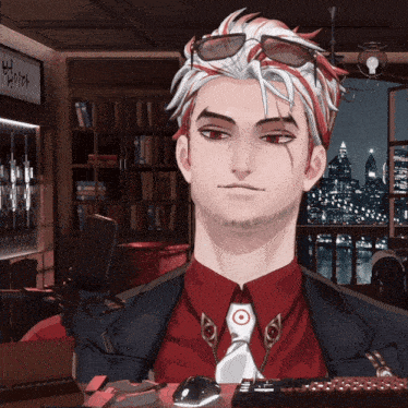 a man in a red shirt and tie stands in front of a bookshelf