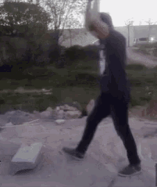 a man in a black shirt is swinging a hammer at something